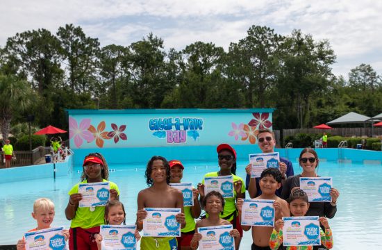 Group of kids holding swim certificates at waterpark