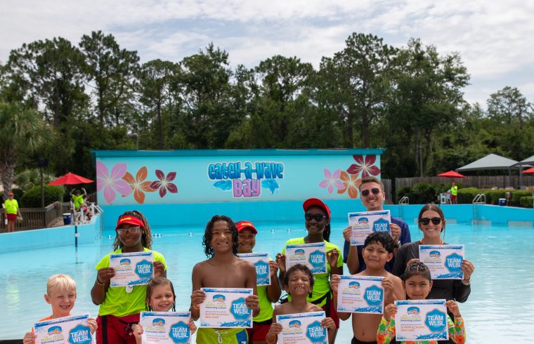 Group of kids holding swim certificates at waterpark