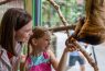 Mother and daughter feeding sloth at zoo