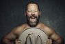 Man holding hat, smiling enthusiastically.