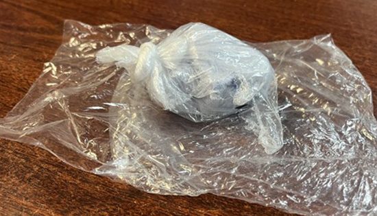 Plastic-wrapped object on wooden surface.