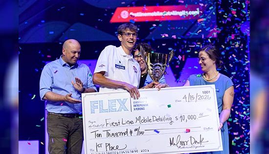 People celebrating with a large award check.