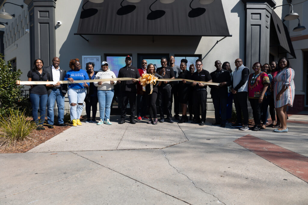 Fin & Feathers Restaurant owners, Ayanna and Damon Johnson (center), pictured along with staff, family, and members of the Southern Georgia Black Chambers who supported their official grand opening with a ribbon cutting ceremony. - Photo Credit, Vocal Flo Entertainment