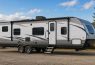Travel trailer parked in scenic outdoor setting.