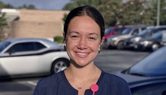 Person smiling in parking lot with cars
