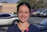 Person smiling in parking lot with cars