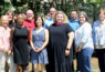 Group of people standing outdoors, smiling.