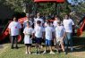 People in white shirts standing by orange tractor