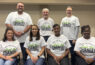 Seven people wearing matching "Be the Change" shirts.