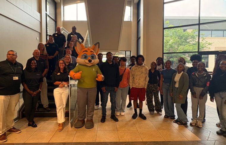 Group posing with person in animal costume.