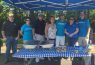 Group under canopy at outdoor event.