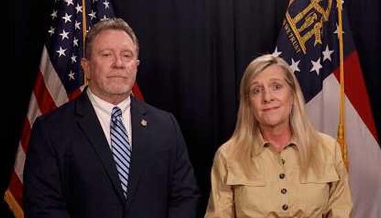 Two people in formal attire before American flags