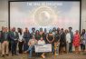Group photo with large check display.